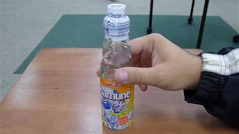 Using your finger or the included plastic opener, push the seal off gently, taking care not to spill the drink inside. . How to open ramune bottle